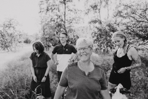 Ein Schwarz-Weiß Foto einer Gruppe von Menschen und einem Hund.