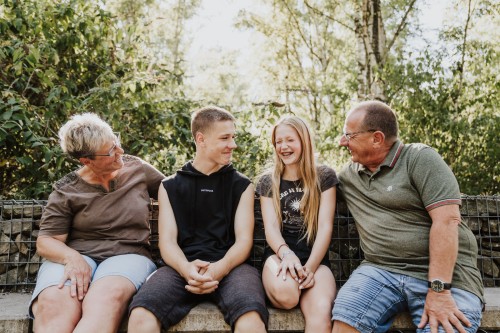 Die Großeltern und deren Enkeln sitzend auf der Bank.