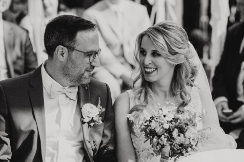 Ein schwarz-weißes Bild von einem Brautpaar, dass sich anschaut.