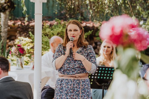 Eine Frau hält ein Mikro in der Hand.