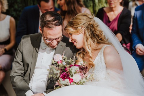 Eine Braut und ein Bräutigam sitzen nebeneinander.