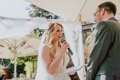 Eine Braut hält ein Mikro und liest was vor.