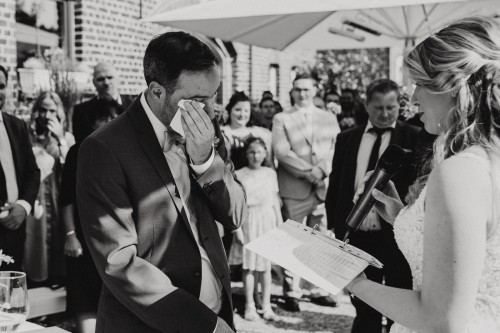 Ein Bräutigam wischt sich eine Träne im Gesicht ab.