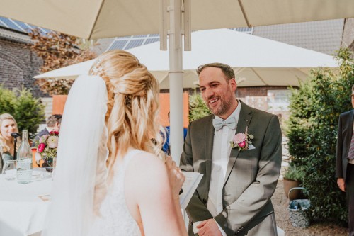 Eine Braut liest ein Eheversprechen ihrem Bräutigam vor.