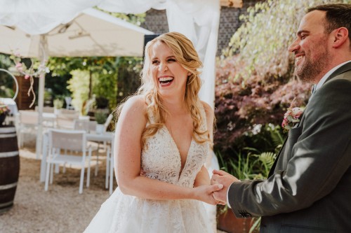 Ein Brautpaar hält sich an den Händen.