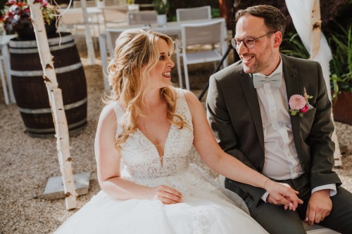 Ein Brautpaar sitzt nebeneinander und schaut sich an.