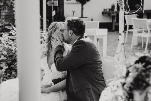 Ein Bräutigam küsst eine Braut.