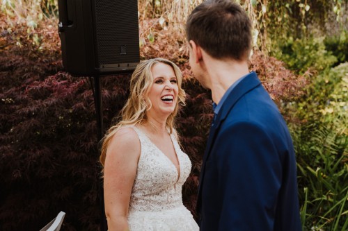 Eine Braut und ein Mann stehen vor Bäumen.