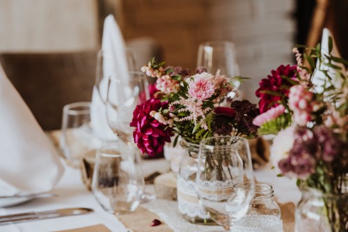 Ein festlich gedeckter Tisch mit Blumen und Servietten.
