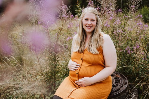 Schwangere Frau in orange-gelben Kleid