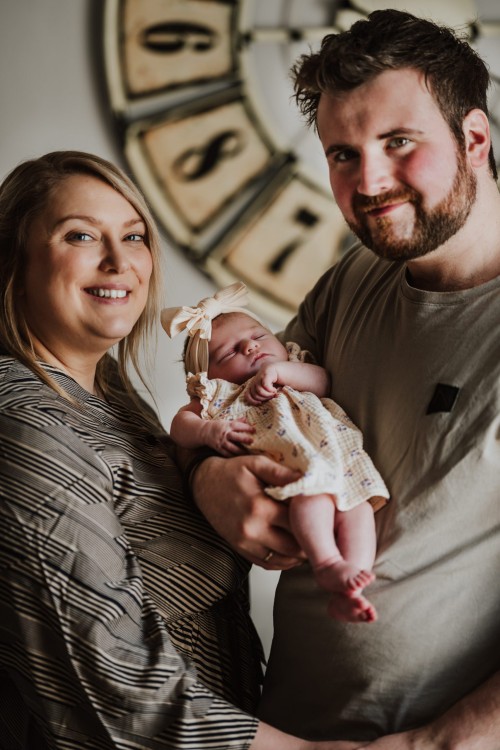 Baby Nella in den Armen der Eltern